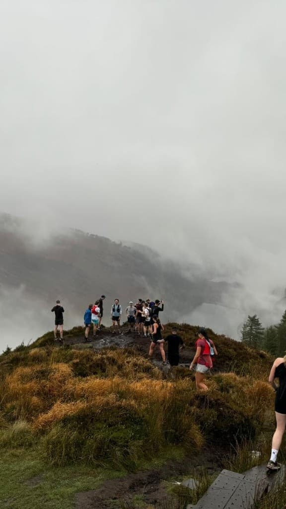 Trail runners gathered on a misty mountain ridge